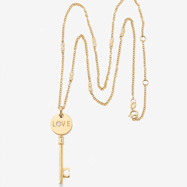 Kate & Mimi Mini Love Key with single round diamond on one side and round diamonds set pavé style on the other side styled view